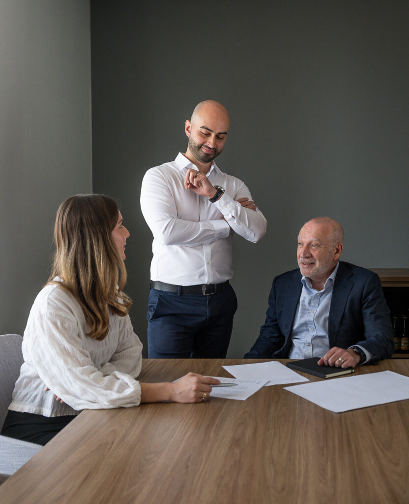 three advisors in a meeting room chatting with papers on the table